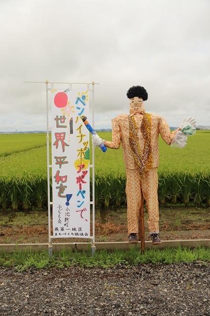 小池新町子ども会による「ピコ太郎」案山子と「ペン・パイナップル、世界平和」と書かれたのぼりの写真