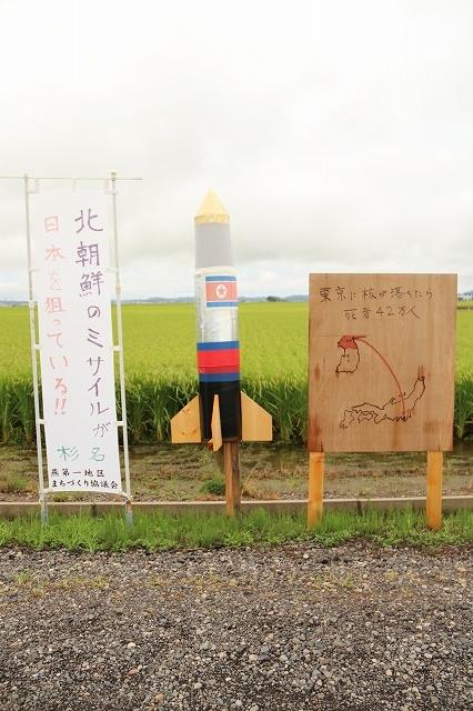 杉名自治会作品による物騒な「北朝鮮核ミサイル」案山子と「北朝鮮の核ミサイルが日本を狙っている」と書かれたのぼりの写真