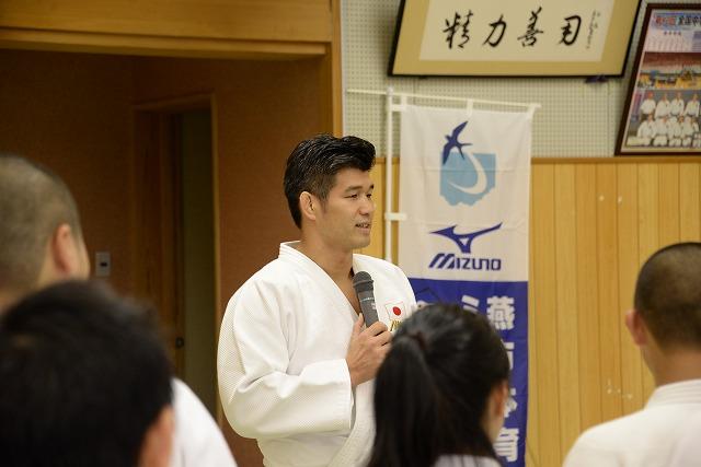 マイクを握って話をしている五輪柔道金メダリスト井上康生選手の写真