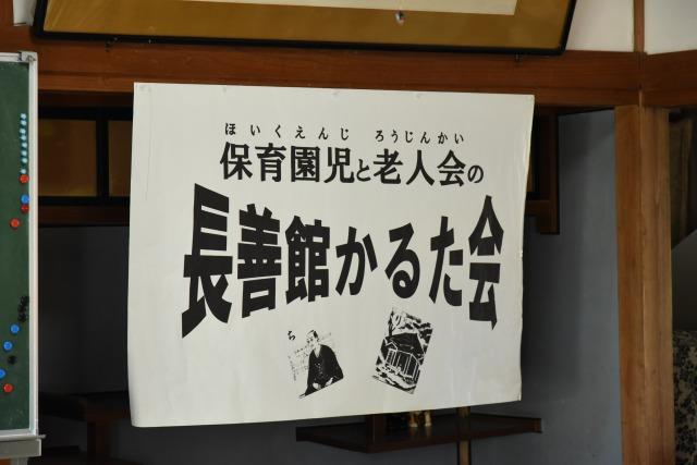 保育園児と老人会の長善館かるた会のチラシが張られた室内の写真