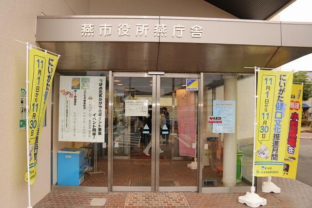 にいがた健口文化推進月間の黄色いのぼりが左右に掲げられている燕市役所燕庁舎の入口の写真