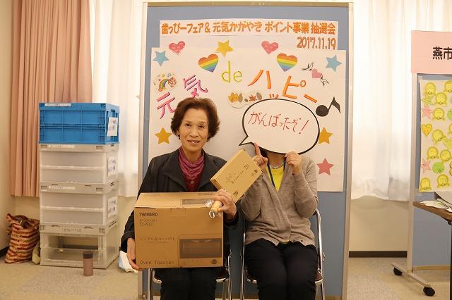 当選した電化製品を抱えて椅子に座っている女性2人の写真