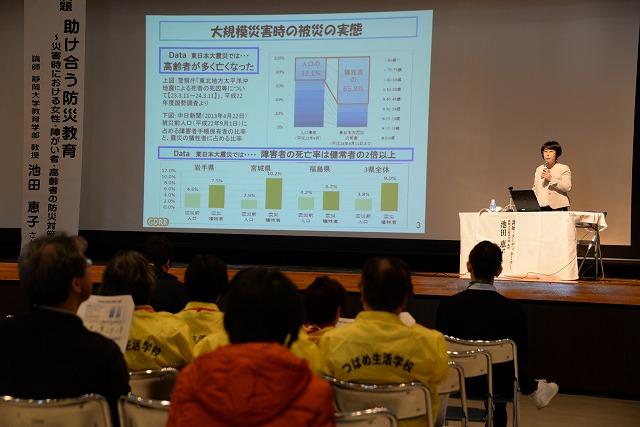 壇上でスクリーンに資料を写しながら防災対策の講演する池田恵子さんの写真