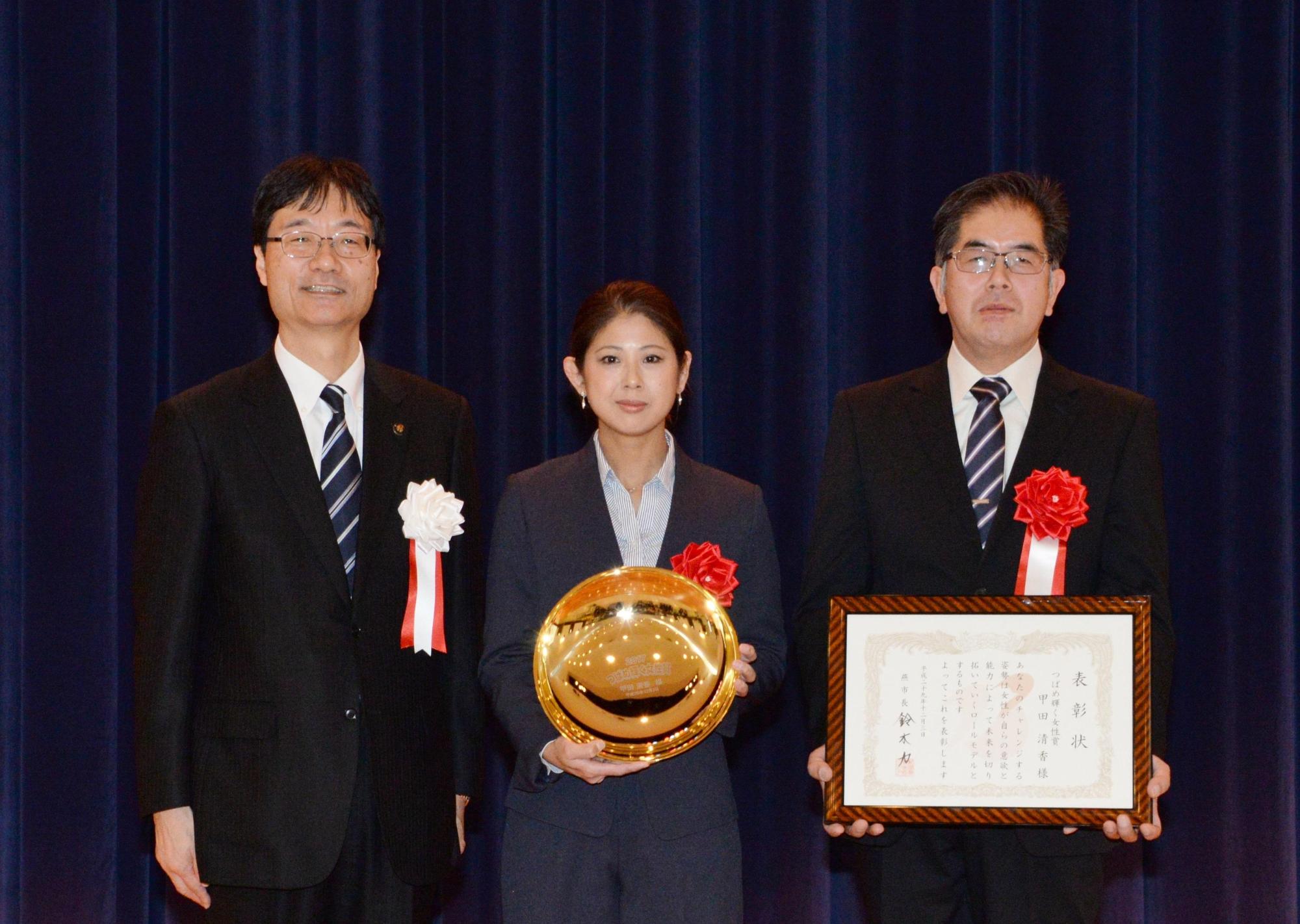 楯を持つつばめ輝く女性賞を受賞した女性と賞状を持つ男性と市長の写真