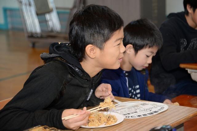 笑顔でおこわ団子を食べている男子生徒の写真