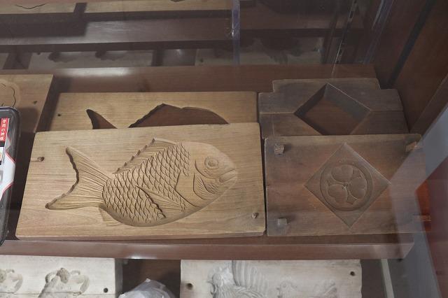 魚の形や家紋がかたどられた粉菓子を作るための木製の型が展示している写真