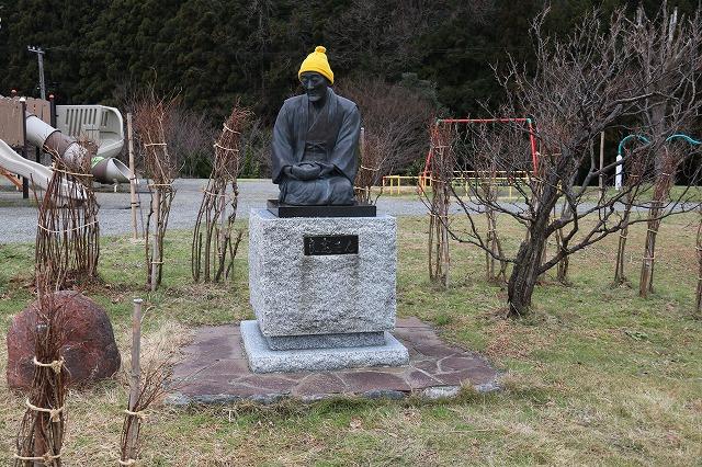 公園に立った「良寛銅像」に黄色いニット帽をかぶせた写真