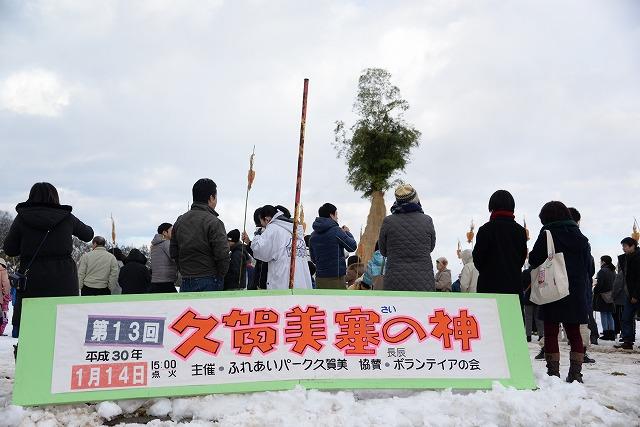 雪の残る中「久賀美塞の神」で集まった参加者たちの写真