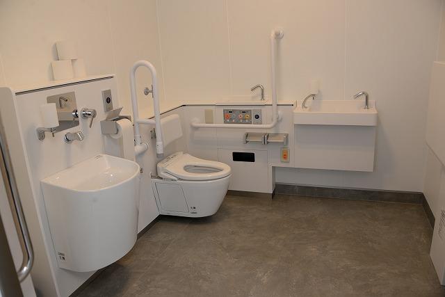 新しくリノベーションされた便器・洗面台・手すりなどの設備が整っている多目的トイレの中の写真