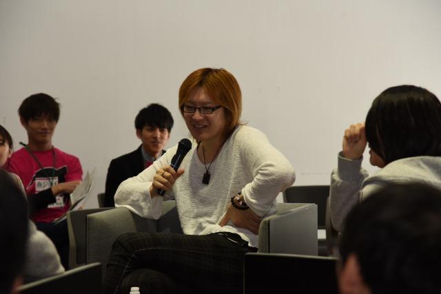 講演会で参加者に囲まれてリラックスしながら講演をしている若新雄純氏の写真