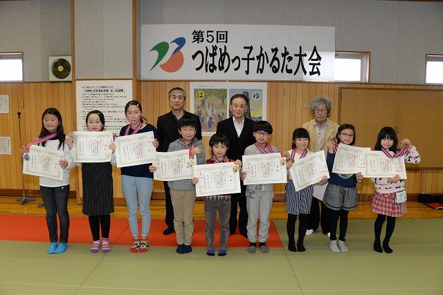 授与された表彰状を手に持ち見せる9人の子供たちと後ろで職員が横に並んだ記念写真