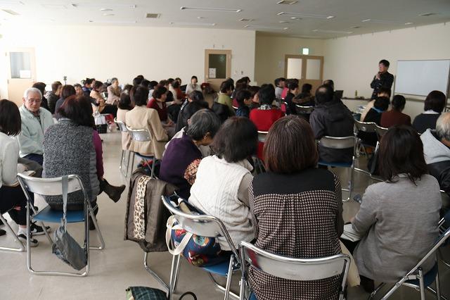 吉田産業会館内で行われている合同研修会にお招きした志賀誠治先生と集まった参加者たちの写真