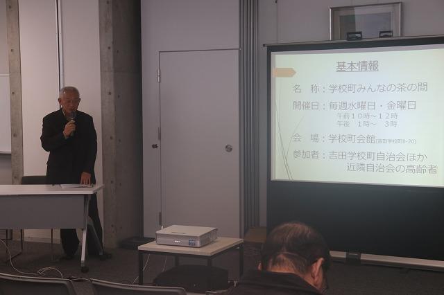 スライドに映し出された「みんなの茶の間」の詳細をマイクを使い立って案内する西村博さんの写真