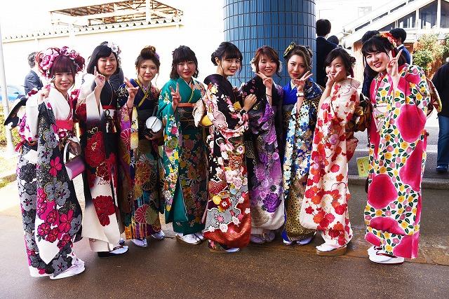 色鮮やかな振袖をきた女性新成人9人が並んでポーズをして記念撮影をしている写真