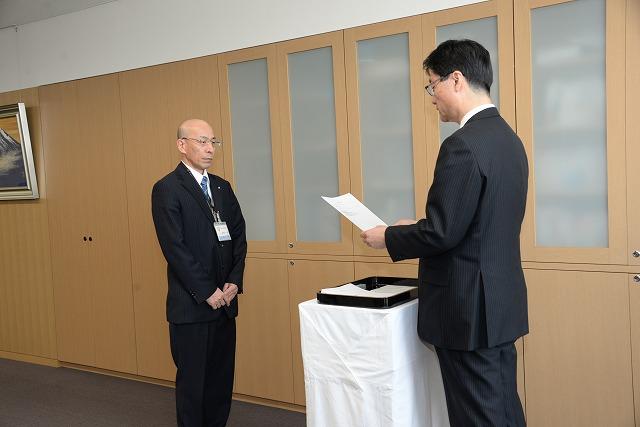 辞令交付式で市長が読み上げる辞令を聞いている清野一徳さんの写真
