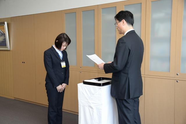 辞令交付式で市長が読み上げる辞令を聞いている本間幸美子さんの写真