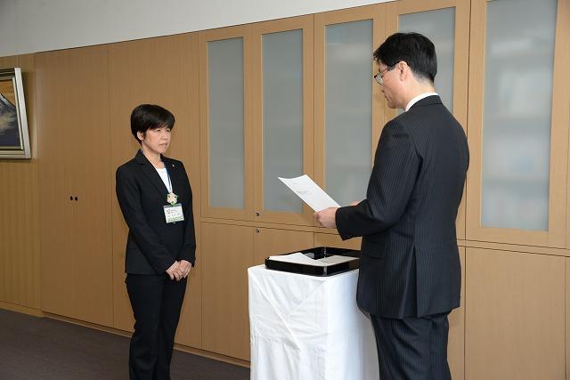 辞令交付式で市長が読み上げる辞令を聞いている丸山美子さんの写真