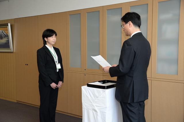 辞令交付式で市長が読み上げる辞令を聞いている小池和恵さんの写真