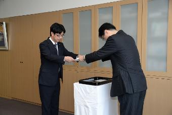辞令交付式で市長から辞令を受け取る廣川統さんの写真
