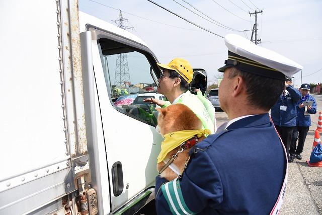 トラックドライバーに交通安全グッズを手渡ししている参加者の様子の写真