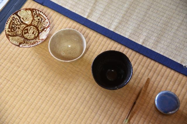 畳の上に器や茶道の道具が並んでいる写真