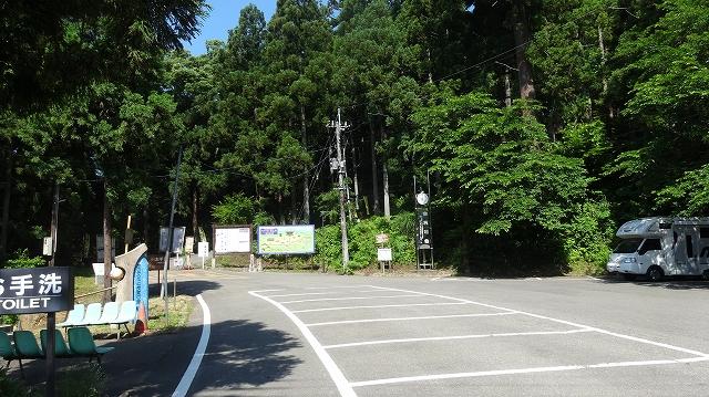 フットパス木々に囲まれたサービスセンターの駐車場の写真