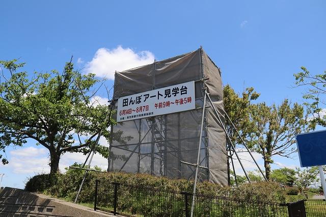 青空のもとに建てられている田んぼアート見学台の写真