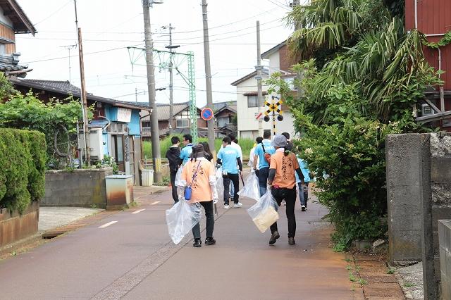 住宅街でゴミを探している青チームとオレンジチームの様子の写真
