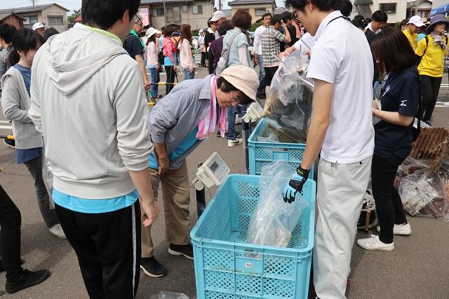 参加者たちが拾ってきたゴミの重さを測っている様子の写真
