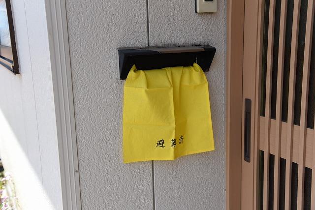 避難済の黄色いタオルが、郵便受けに掛けられている玄関の写真