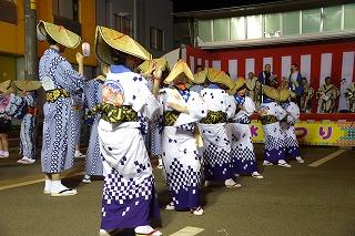 笠をかぶった和服の人たちが、並んで踊っている写真