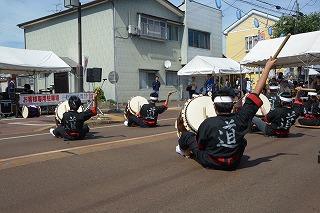 路上に座って和太鼓を演奏する人たちの写真