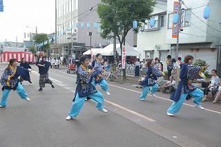青と水色の衣装を着た人たちが、足をあげて踊っている写真