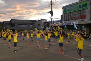 黄色いシャツを着た子どもたちが、並んで踊っている写真