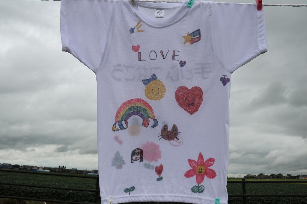 星、太陽、虹、花などをイメージした小さい絵がたくさん描かれているTシャツの写真