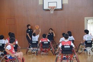 車椅子に乗った子どもたちが、チームでバスケットボールをしている写真