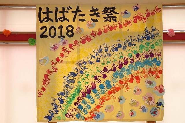 「はばたき祭り2018」という文字と、たくさんの手の跡でデザインされている黄色い布の写真