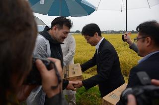 雨の中、差し入れをしている人達の写真