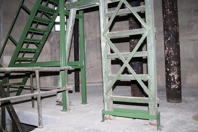 旧浄水場配水塔の内部にある木製のはしごと、奥にある鉄製の急な階段の写真