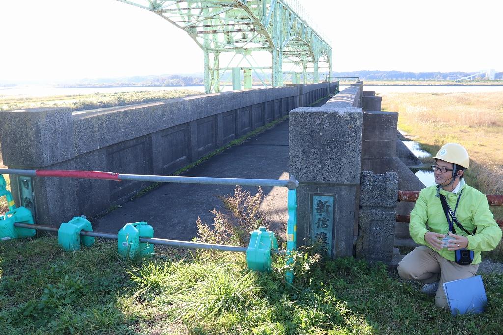大河津分水公園にある使われなくなったゲートの開閉により水位調節が可能な堰のあるダムの脇にあるパイプでできたゲートで入り口を塞がれた新信濃川と書かれた橋の写真