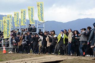 黄色いノボリの立つ会場と参加者たちの写真