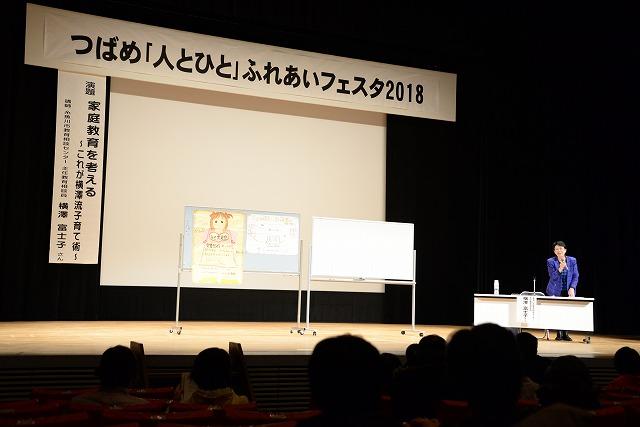 壇上で「家庭教育を考える」をテーマに講演する青の服を着た主任相談員の横澤富士子さんの写真