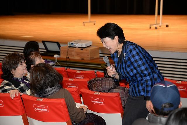 マイクを持ち客席に降りて参加者たちに質問を投げかける横澤さんの写真