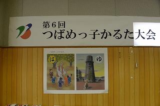 壁に大きく貼り出された「つばめっ子かるた大会」の文字が書かれた看板と、かるたのイラストが書かれたポスターの写真