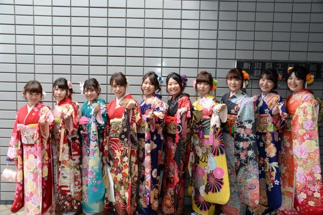 華やかな和服の女性たちが横に並び、和服の袖を持つポーズをしている写真