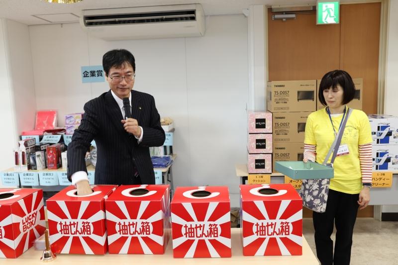 並べられた抽選箱の一つに、市長が手を差し入れている写真