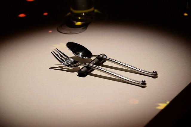 銀色のフォークとスプーンが、テーブルの上に並んで置かれている写真