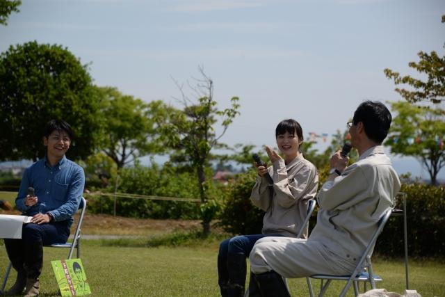 椅子に座りマイクを片手に市長と朝倉あきさんがトークをしている様子の写真