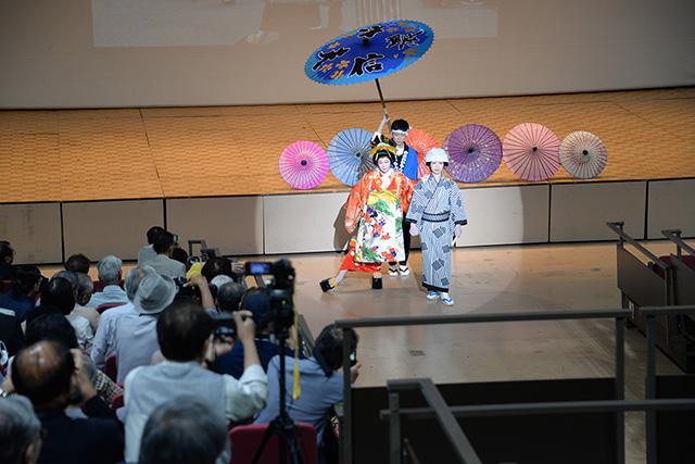 着物を着た演者が和傘を手に持ちパフォーマンスをしている写真