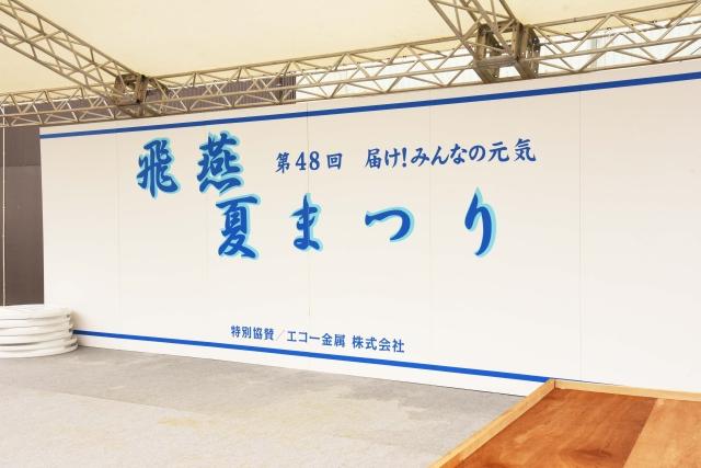 白地に青で飛燕夏祭りと書かれた大きな看板の写真